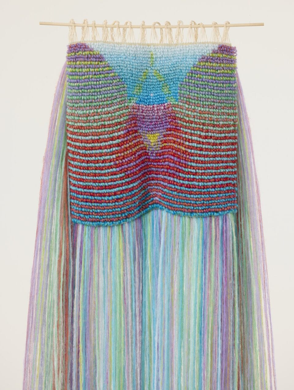 an abstract, bright weaving with long fibers draping from the sides and the bottom