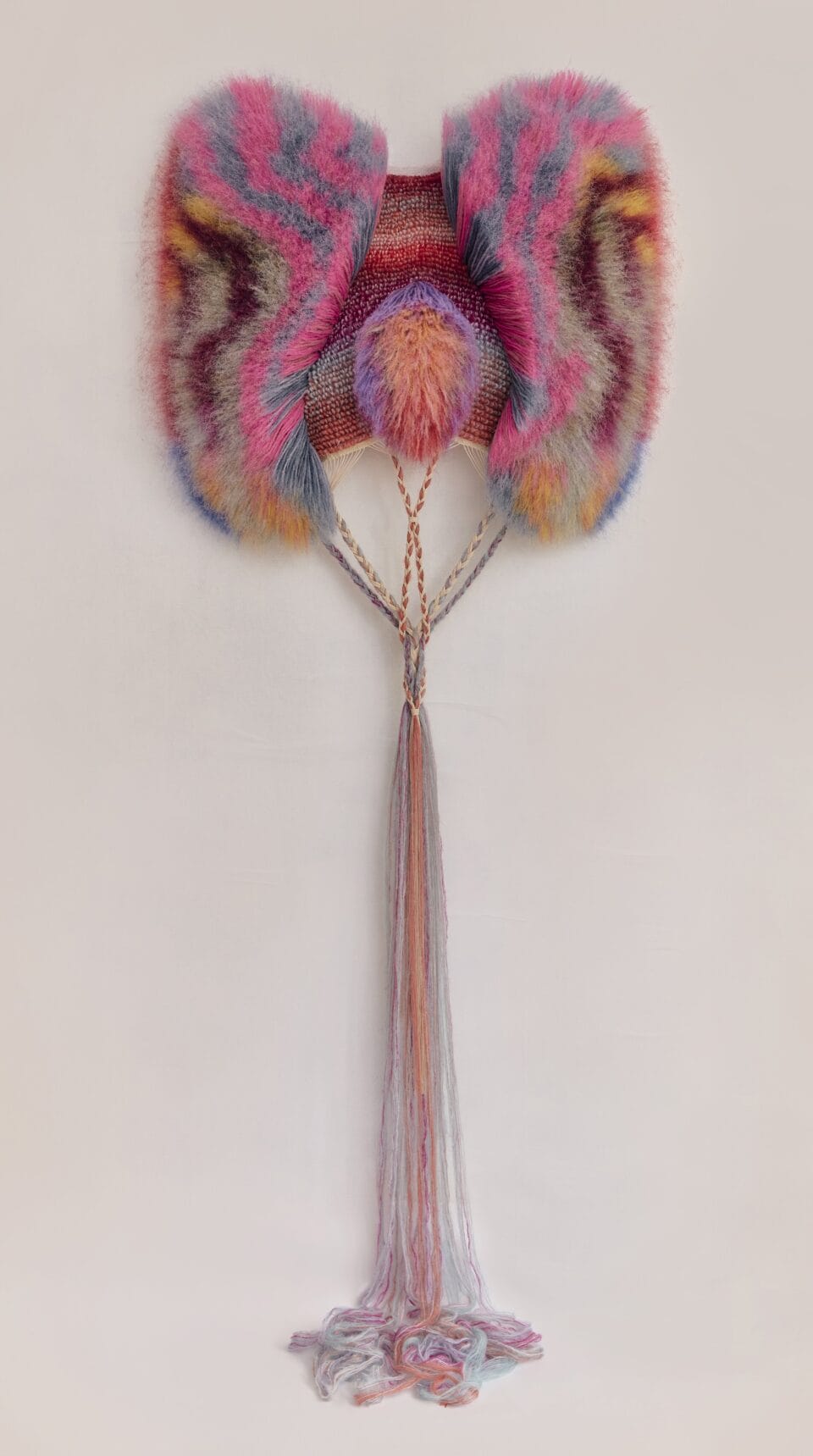 an abstract, bright weaving radiating fiber in other colors into a puffy form, with long fibers gathered and draping long at the bottom