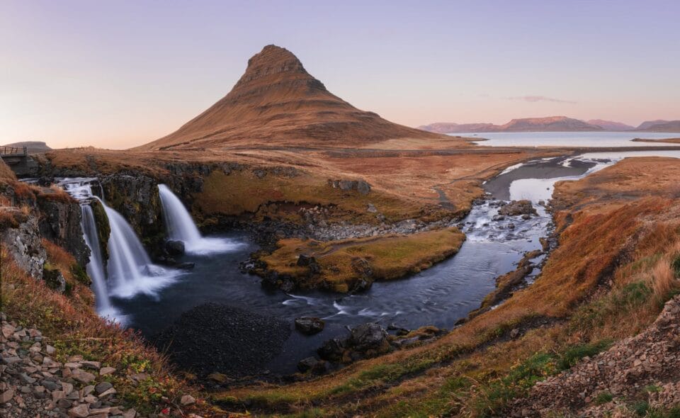 an Iceland landscape at dawn with mountains, plateaus, rivers, and waterfalls