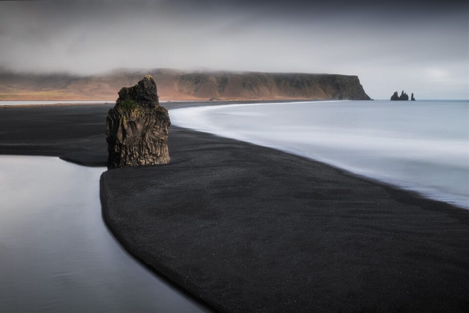 a black sand beach near the cliffs in Iceland