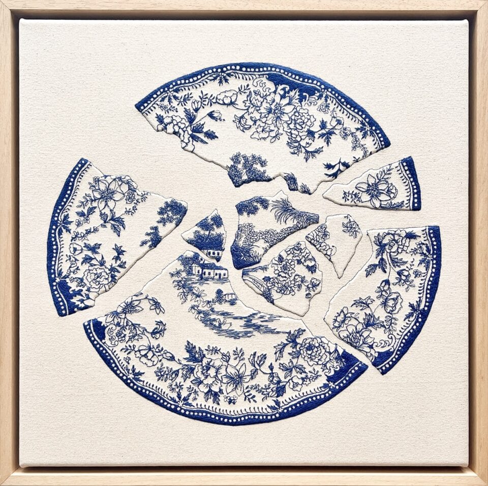 an embroidery of a blue-and-white porcelain plate broken into pieces