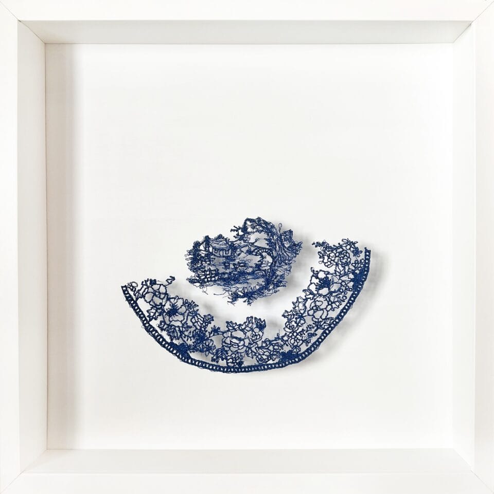 a lacework art piece of a blue-and-white porcelain motif on a white background