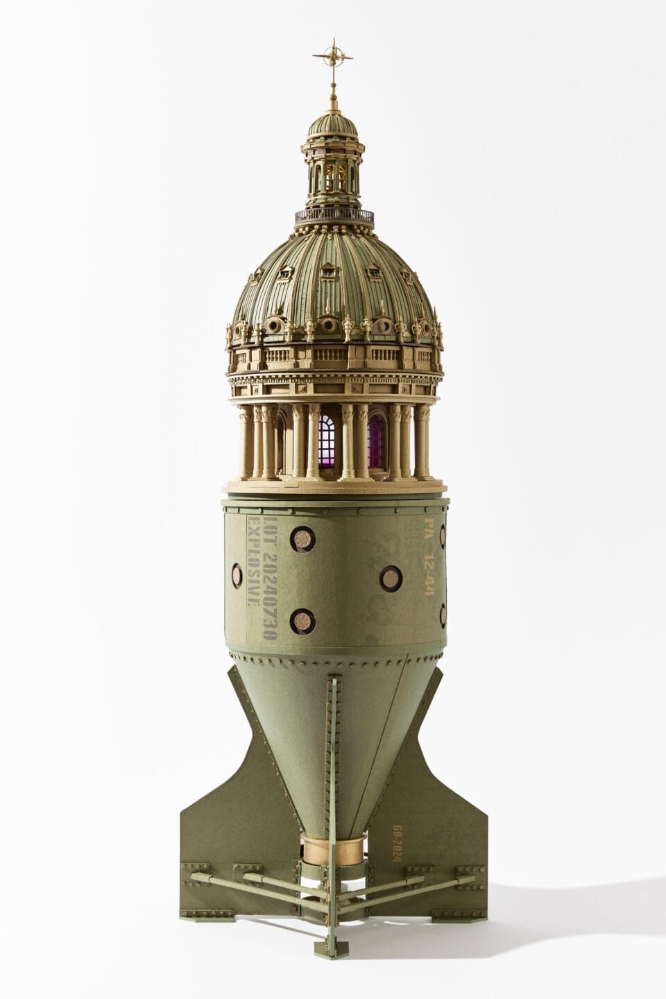 an intricate cardboard sculpture of an elaborate cathedral dome on top of the base of a missile