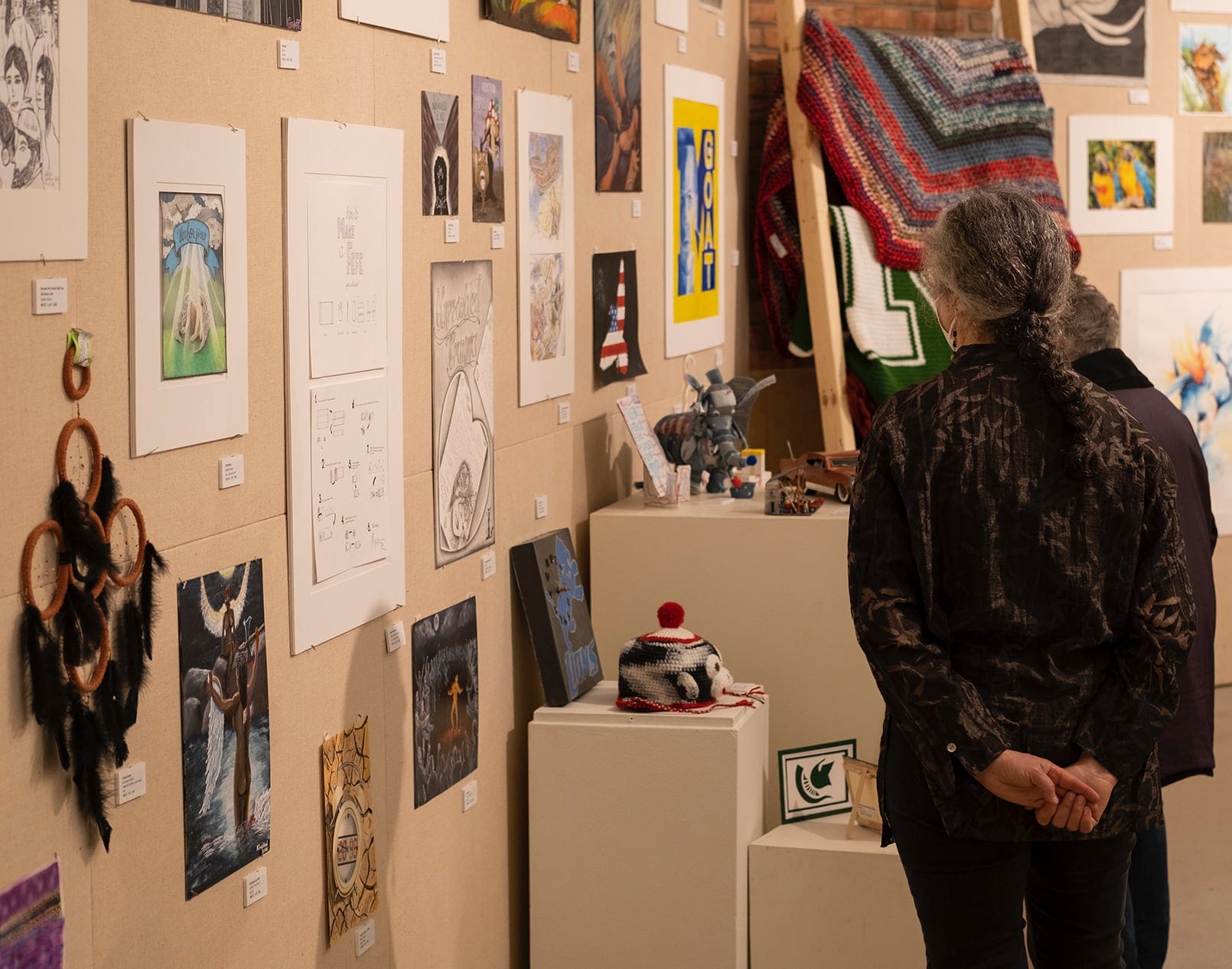 A photo of a woman looking at an art exhibition