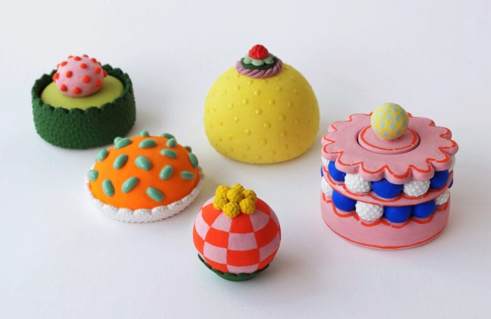 a selection of confectionery-inspired sculptural objects in bright colors with frosting-like details