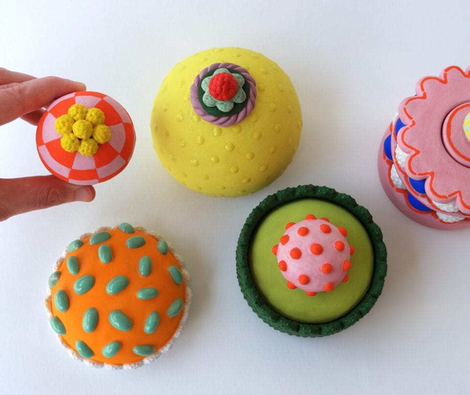 a selection of confectionery-inspired sculptural objects in bright colors with frosting-like details