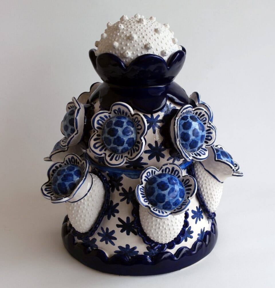 a confectionery-inspired ceramic vessel with an ice cream scoop-like top on the lid and blue flowers around the body