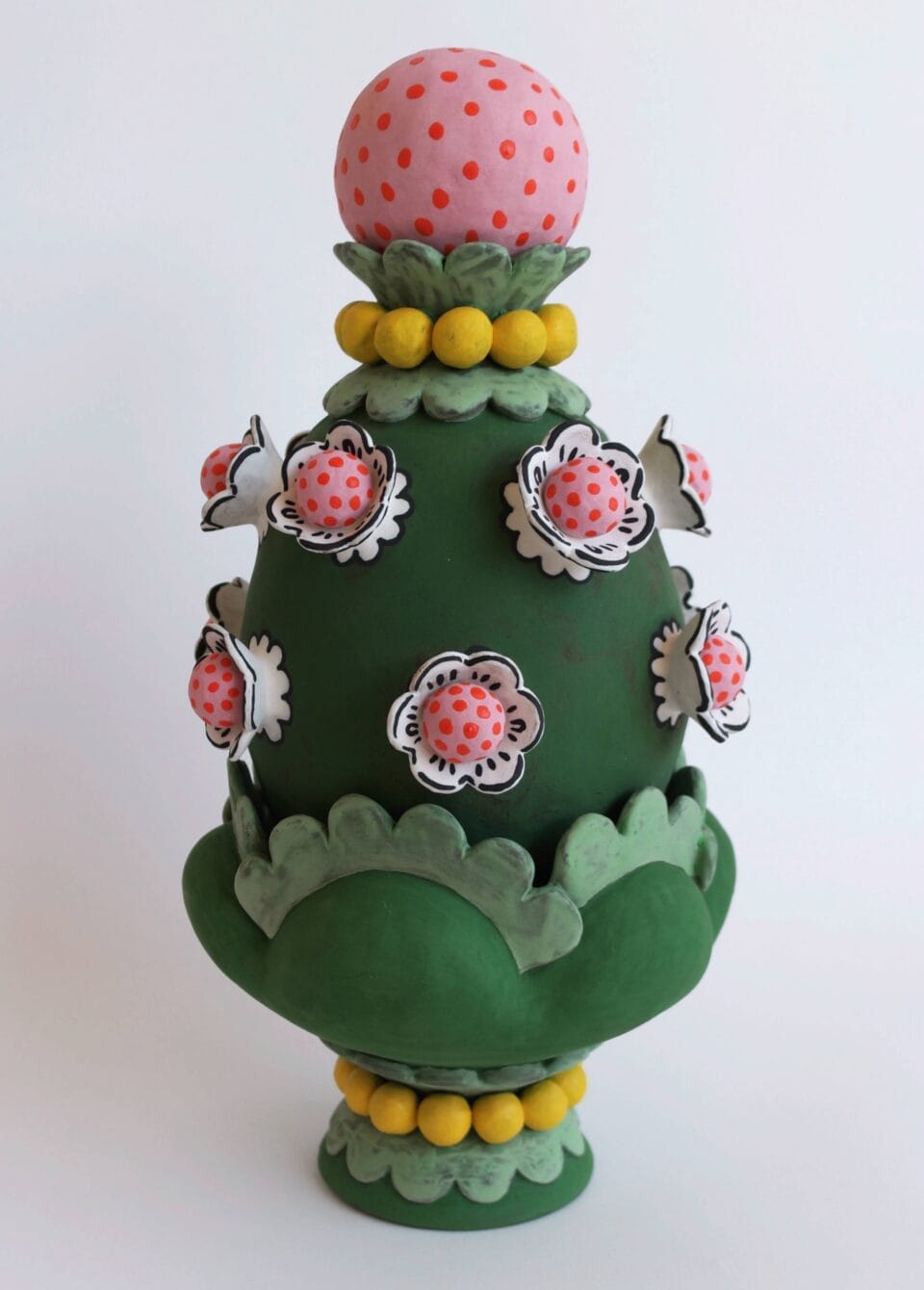 a confectionery-inspired ceramic vessel with a topiary-like top on the lid and pink flowers around the body