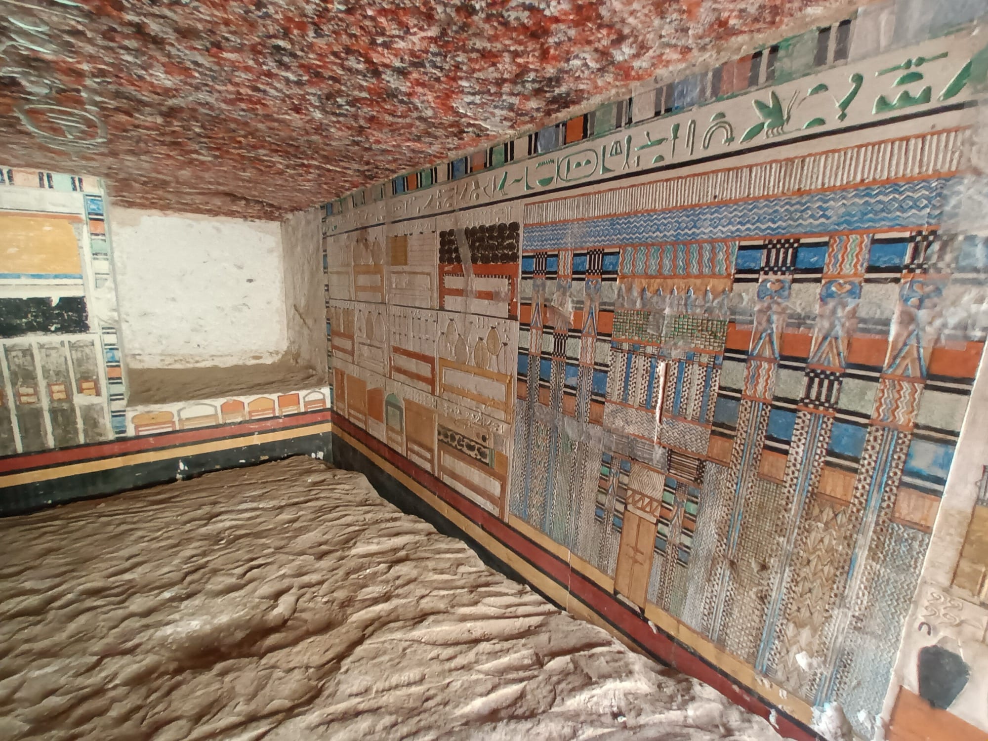 the interior of a kiln tomb in Saqqara of a doctor named Tetinebefou, with brightly colored walls and relief carvings in stone