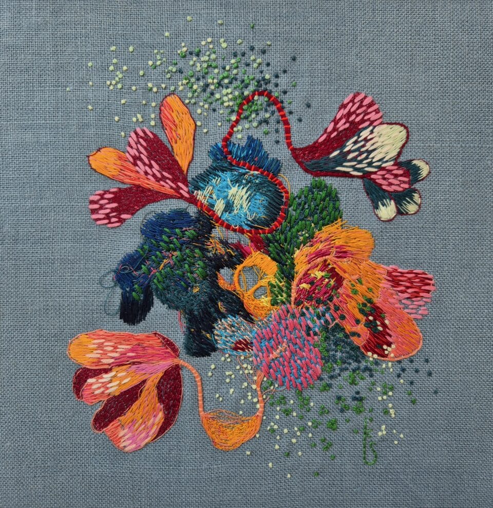 a colorful abstract embroidery on blue fabric