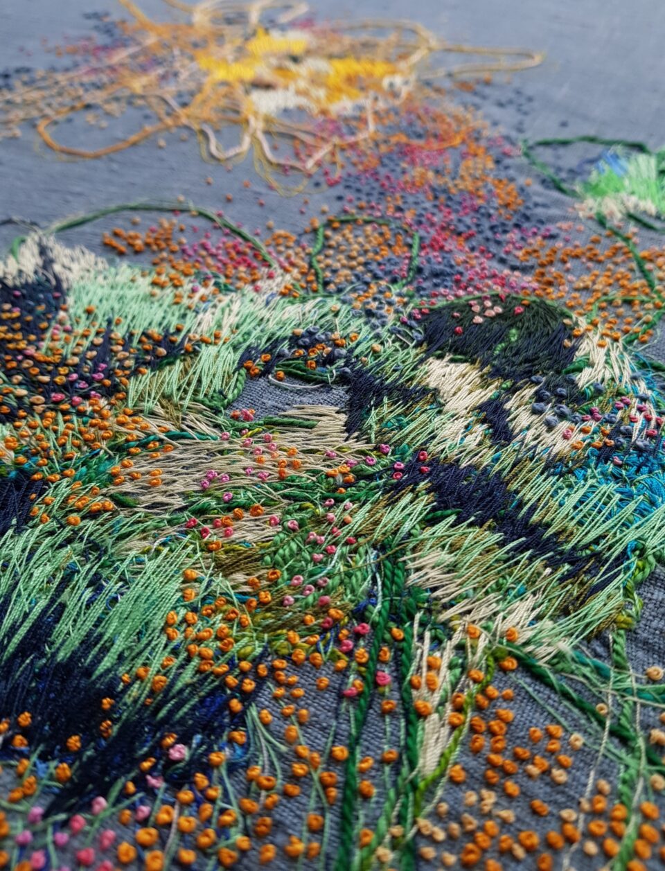 a colorful abstract embroidery on blue fabric