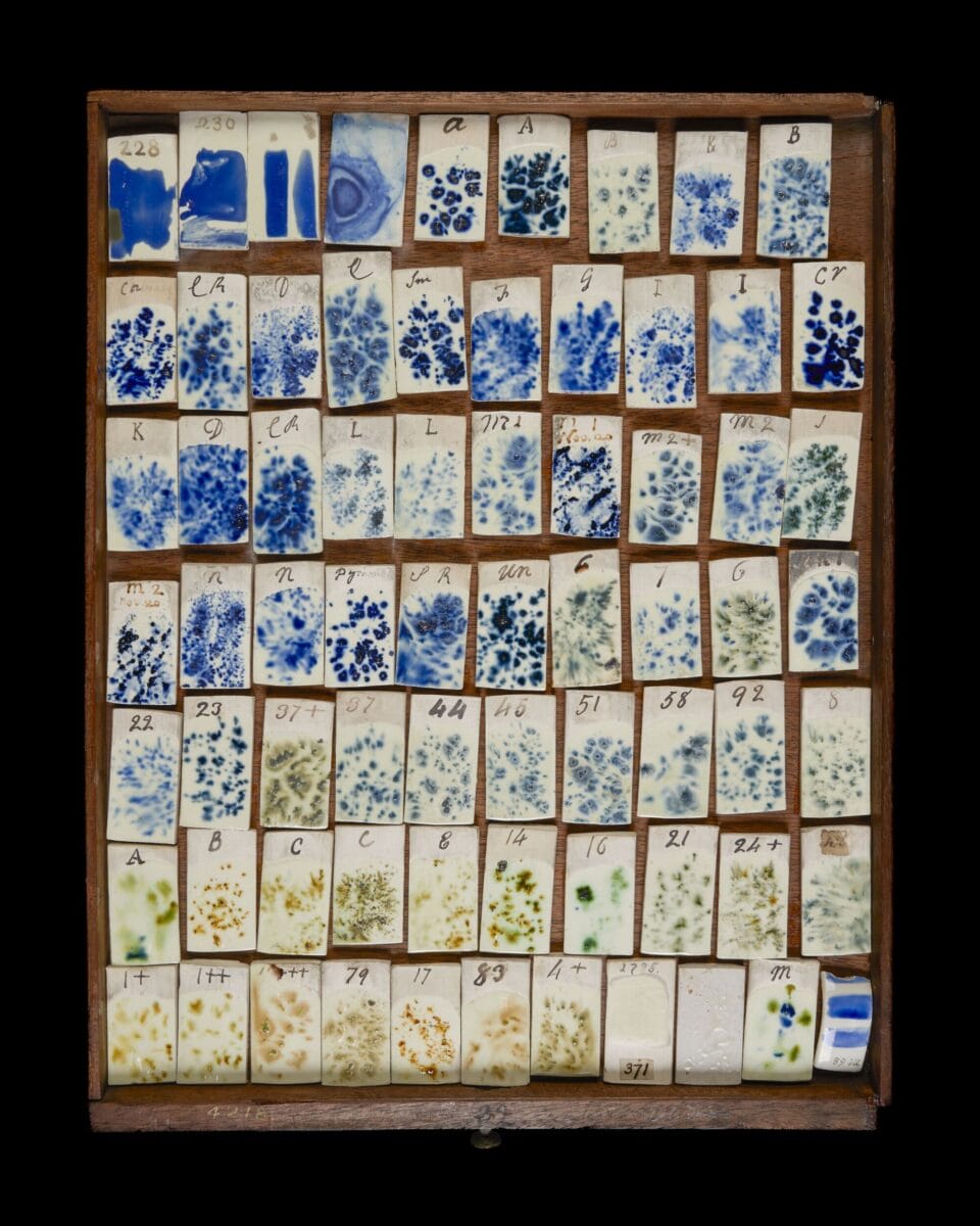 a tray of various shapes of ceramic pieces glazed with different colors