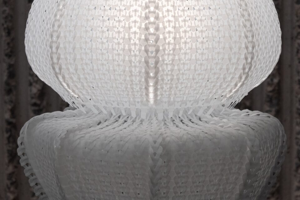 a detail of a white jellyfish-like lamp made of white knitted plastic