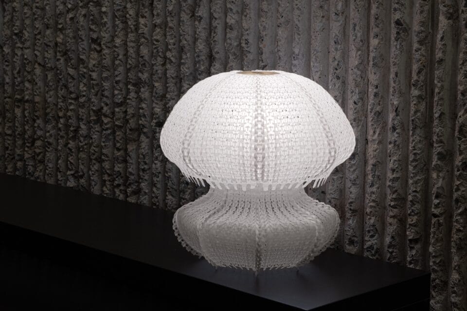 a white jellyfish-like lamp made of white knitted plastic