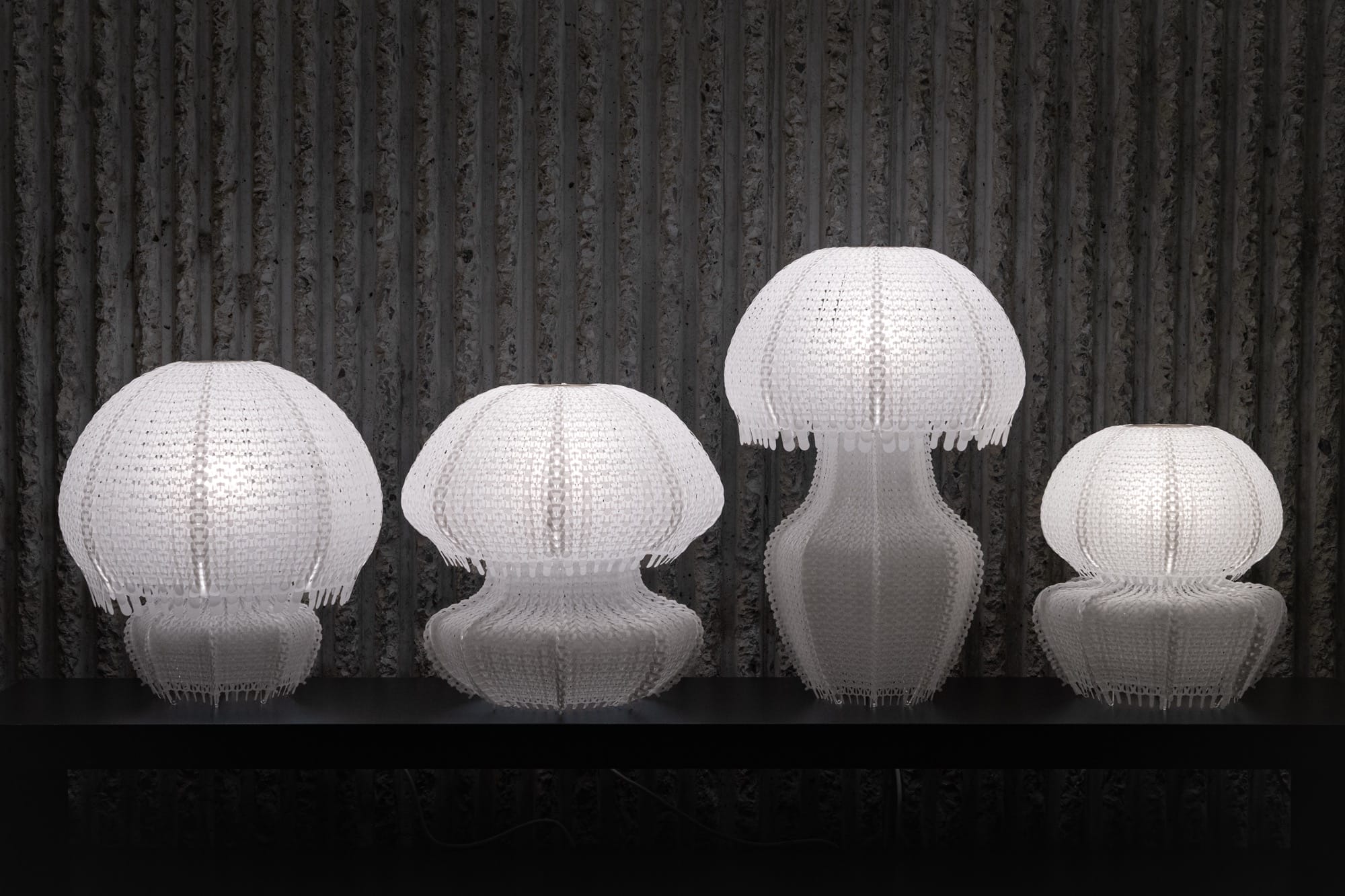 four white jellyfish-like lamps made of white knitted plastic