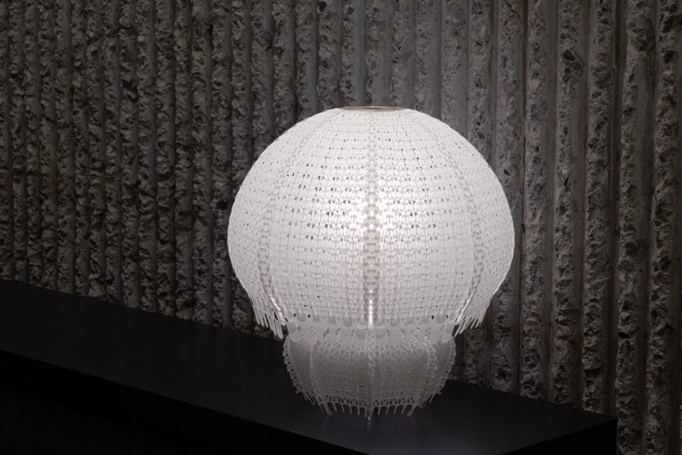 a white jellyfish-like lamp made of white knitted plastic