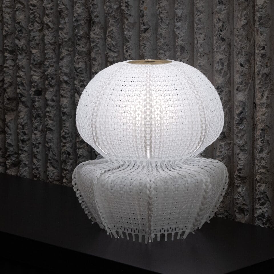 a white jellyfish-like lamp made of white knitted plastic